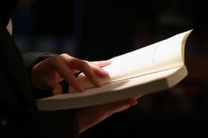 person reading book on black table